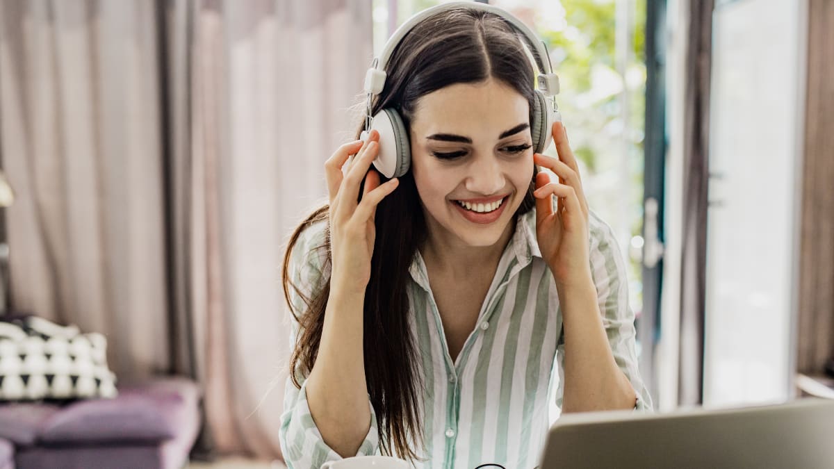 Woman smiling with headphones on her computer