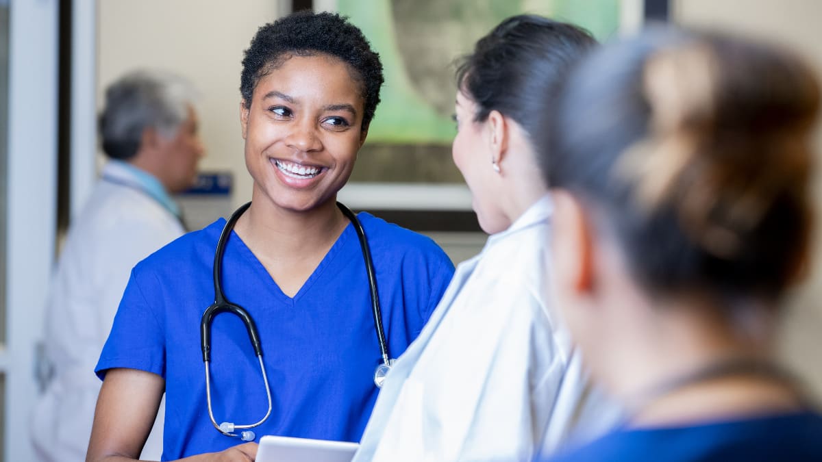 Smiling nurse talking to a doctor