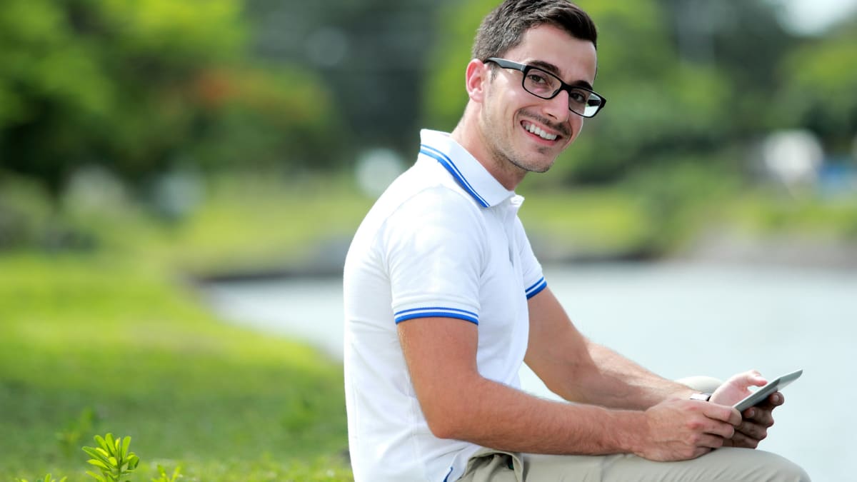 Smiling male student in a park