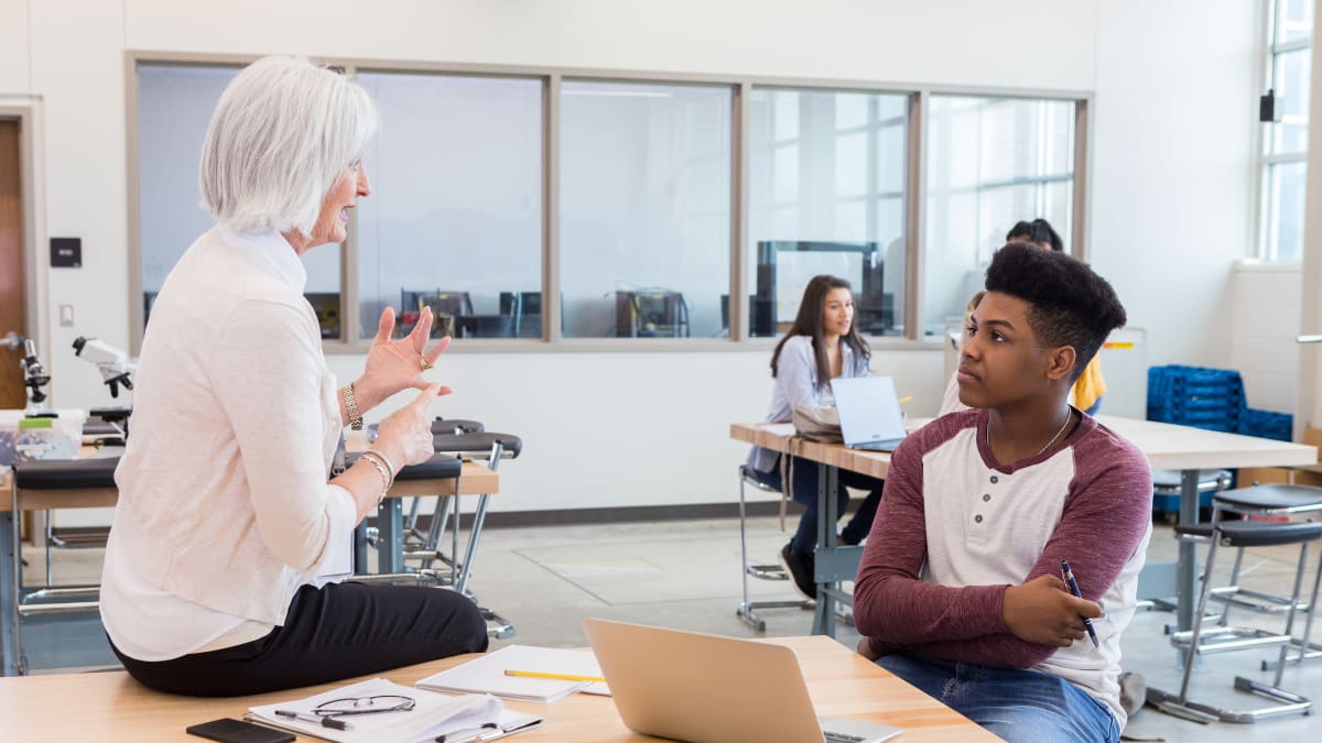 Teacher speaking to a student in a lab