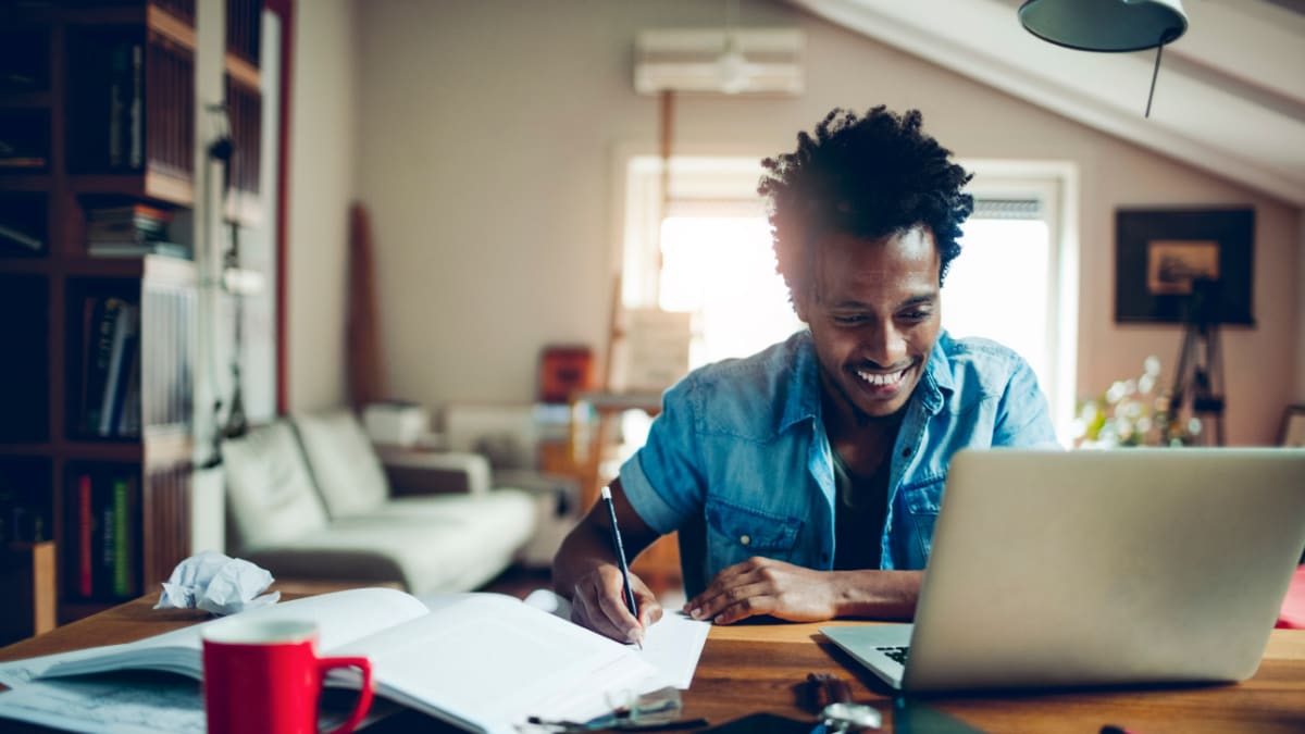 Happy male student working from home