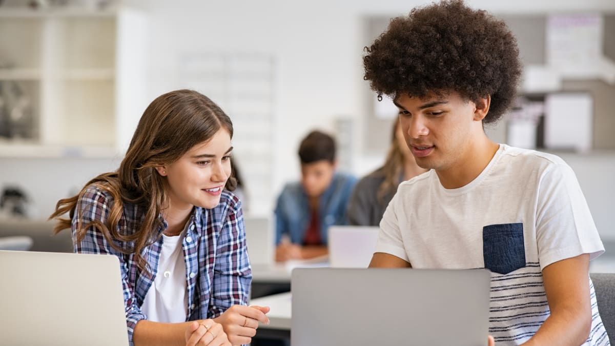 Two students working together on a laptop