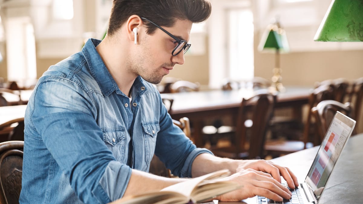 man working on a laptop in the library