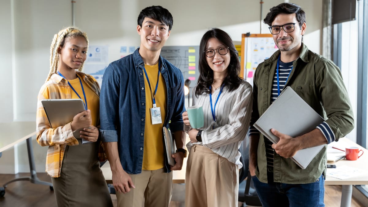 Four young professionals with lanyards