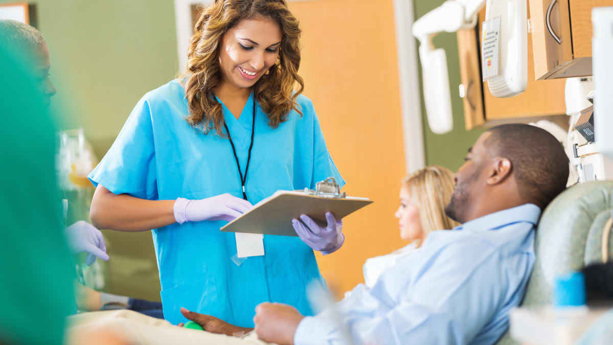 Female phlembotomist talking to a patient