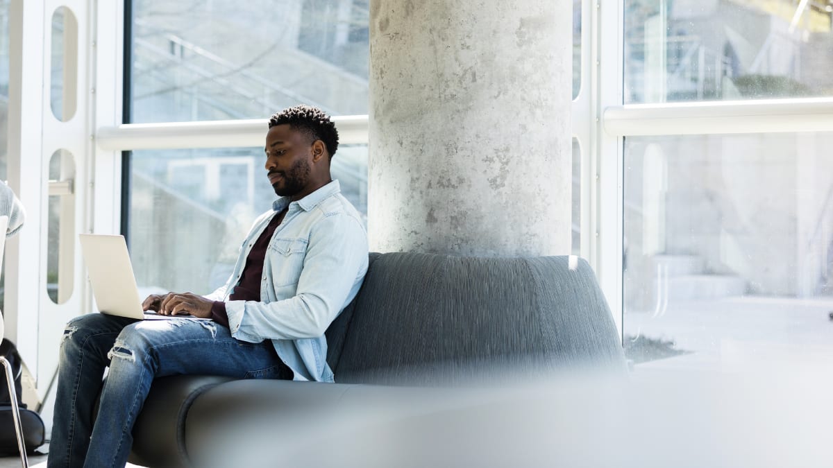 Man working on a sofa in an office building