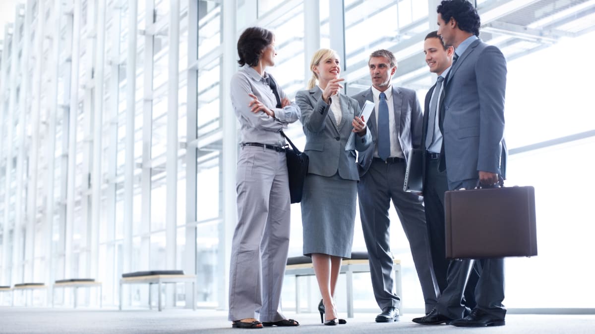 Businesspeople standing and talking with briefcases