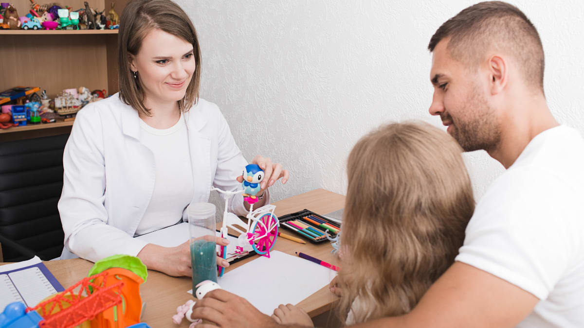 Psychologist at a desk speaking to a child