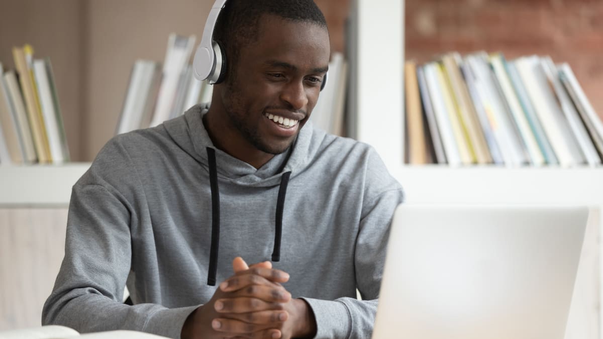Male student smiling at a laptop