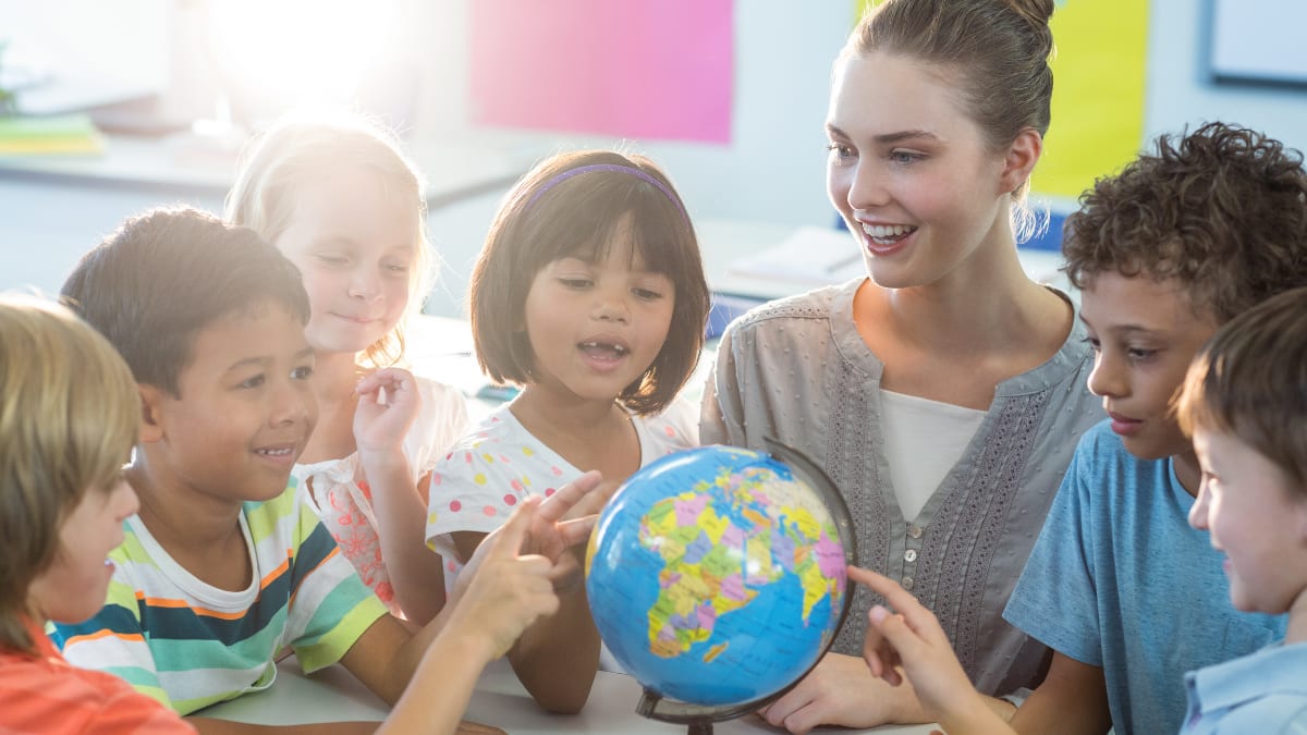 Female teacher teaching children about the Earth