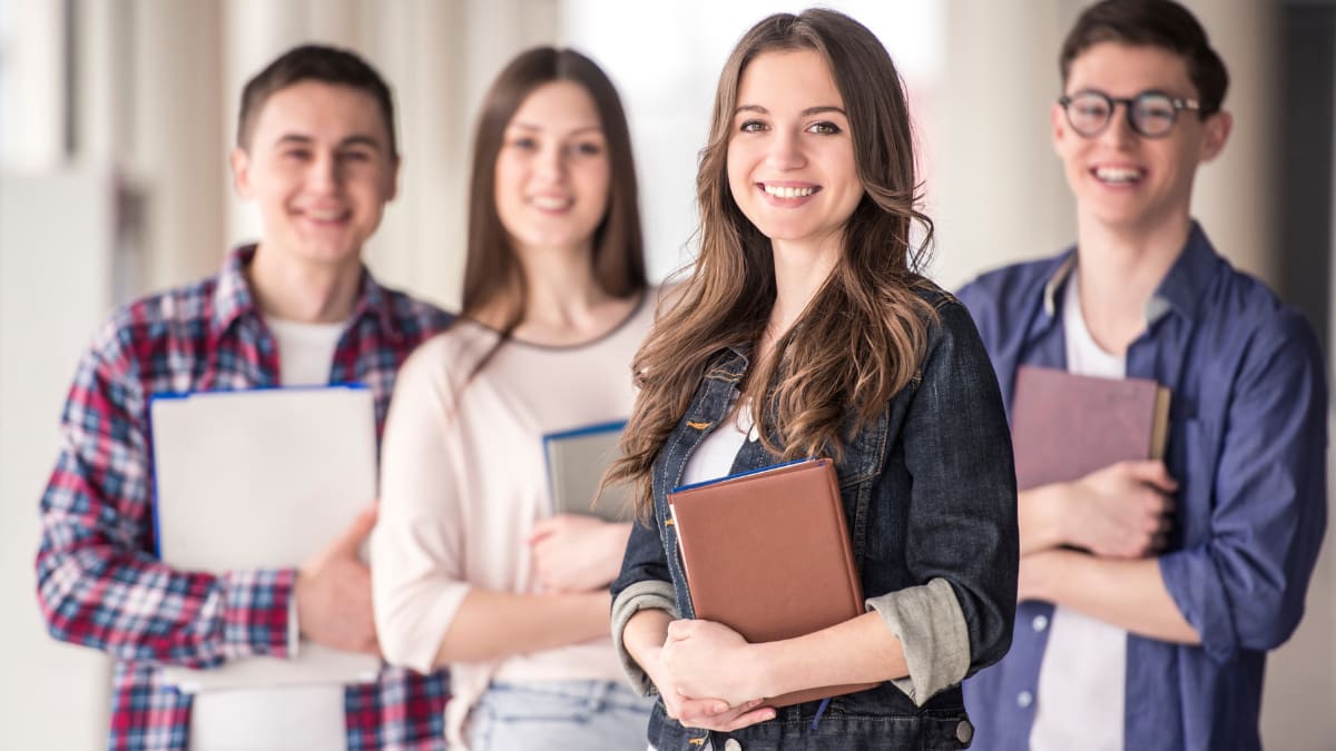 Group of happy students and their notebooks