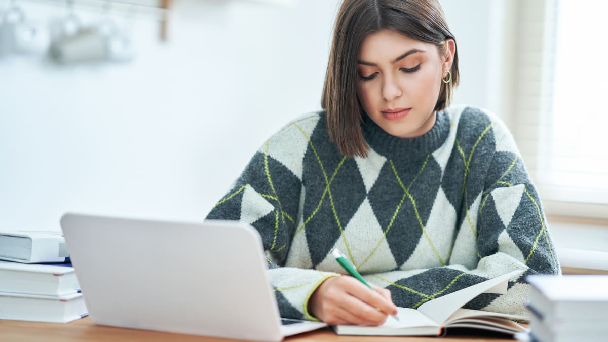 Woman with short hair writing in a notebook