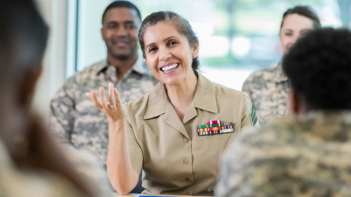 Smiling female military officer talking to a group