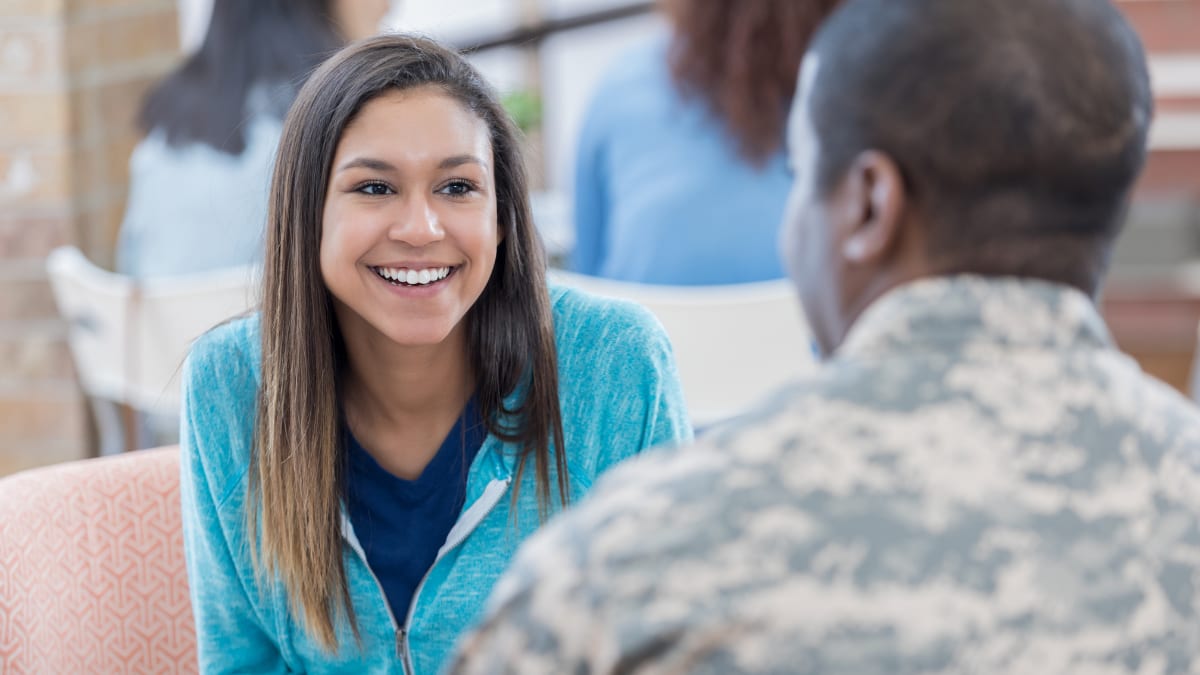 Female civilian talking to a man in a military uniform