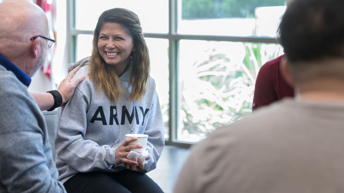 Smiling woman in a group with an Army sweatshirt