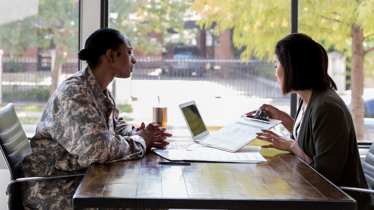 Woman in a military uniform working with a female civilian