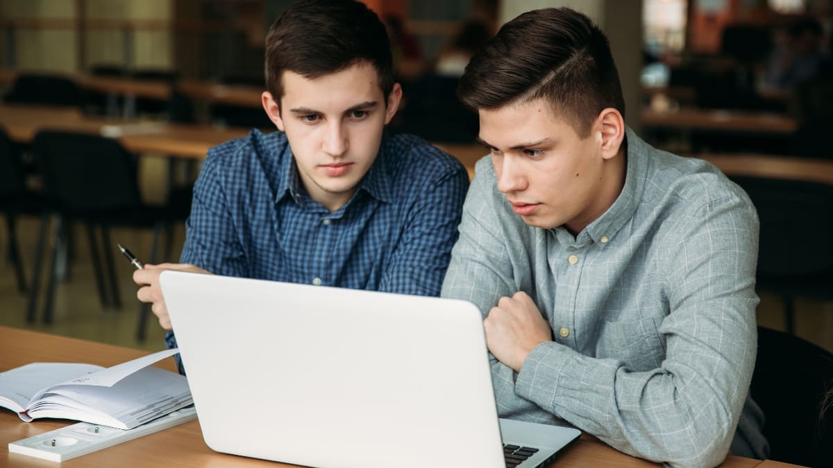 Two male students studying on a laptop together