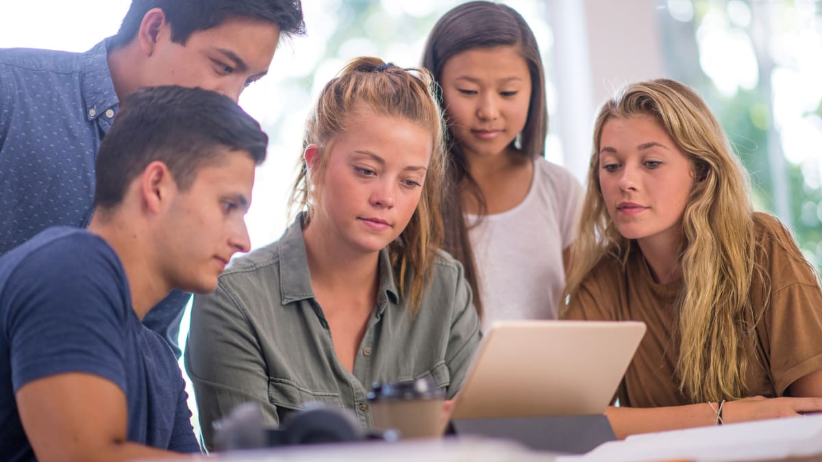 Group of students from a bible college looking at a laptop