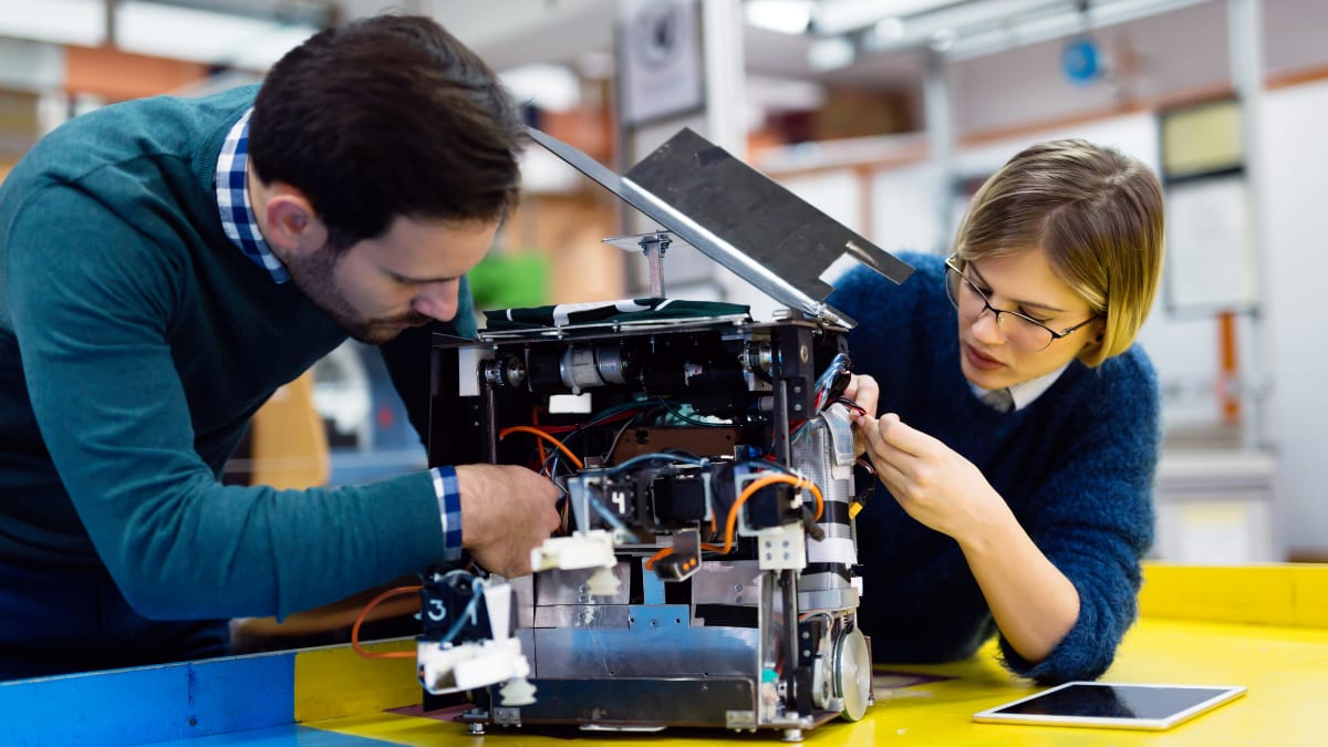 Two students working on a machine