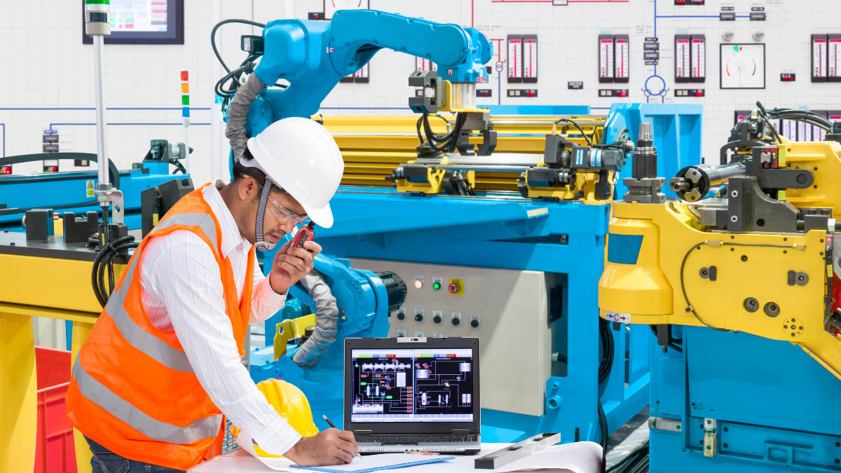 Man with a hardhat working on a machine