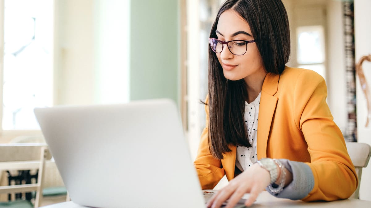 Woman with glasses working on laptop