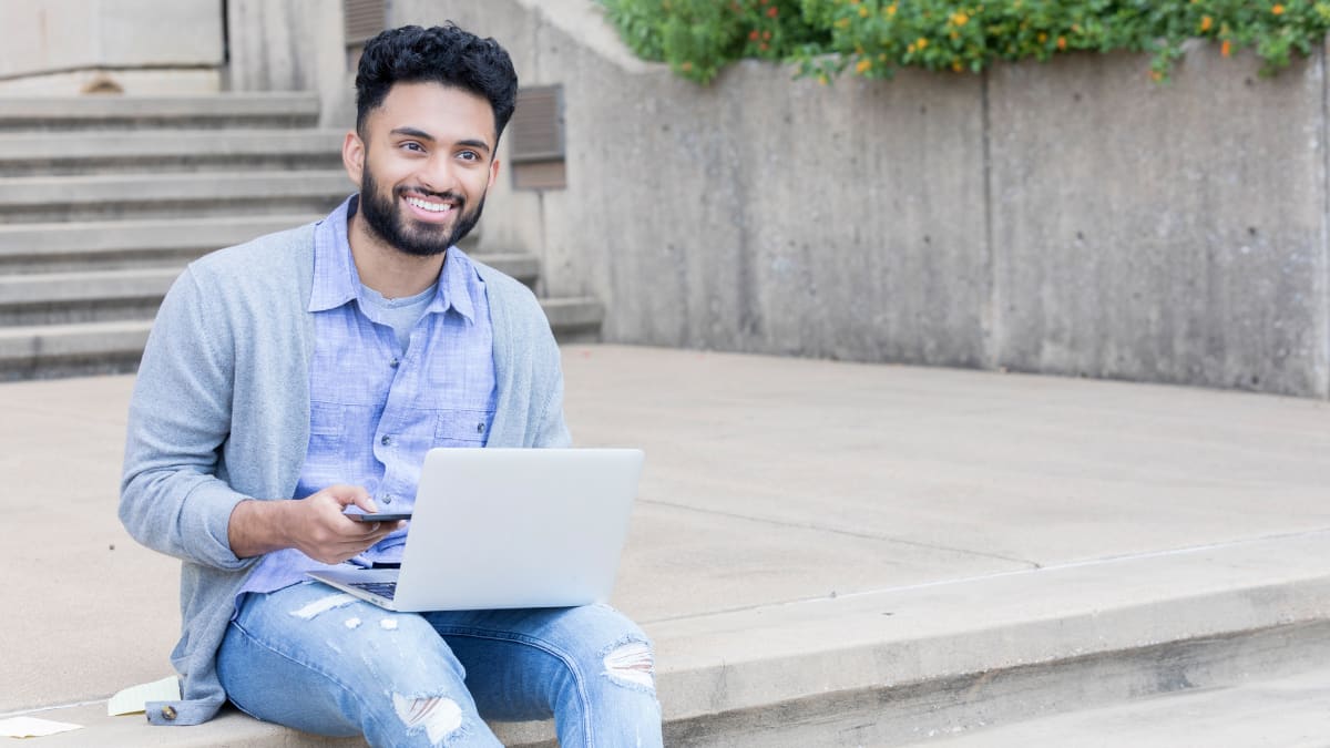 Happy male student with laptop