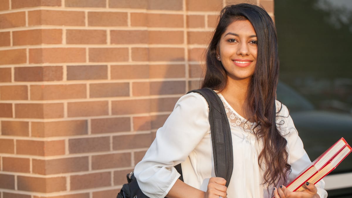 Happy female student with books