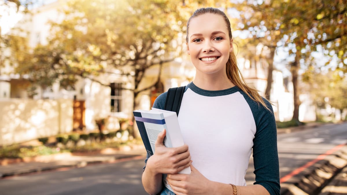 Female student smiling and holding books