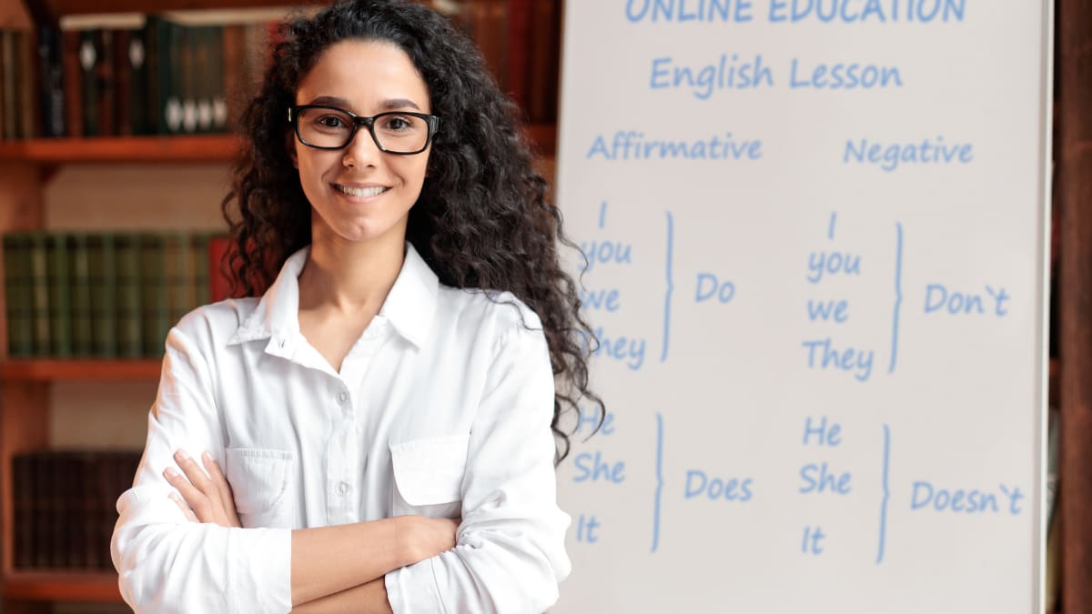 English teacher standing in front of a whiteboard.