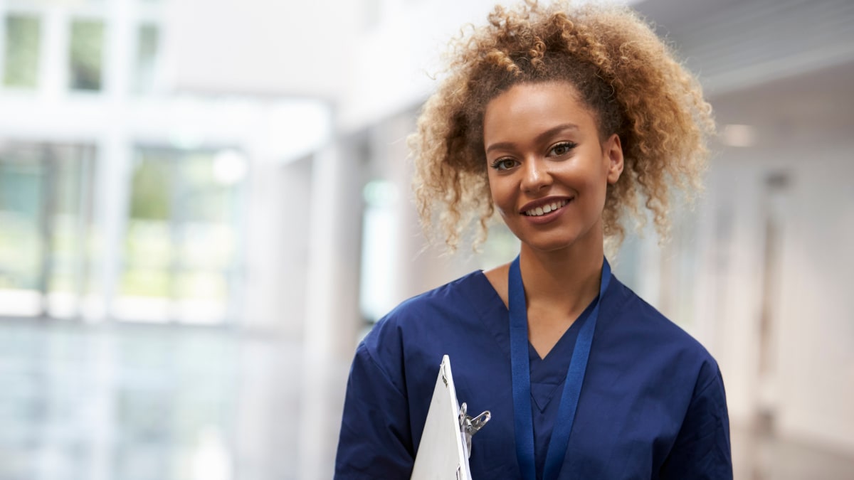 Smiling female nurse holding a clipboard