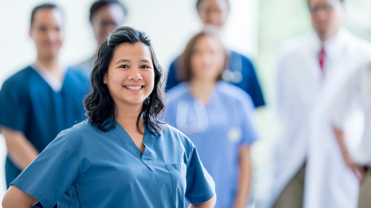 Female nurse standing in front of a group of health professionals