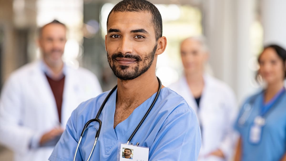 Male nurse standing in front of a group of health professionals