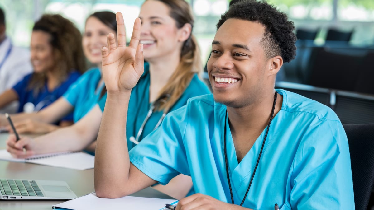 Male nurse answering a question in a nursing class