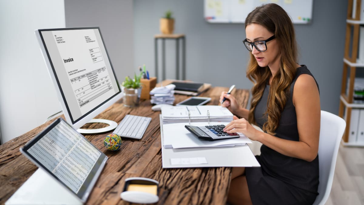 accountant sitting at her desk using a calculator