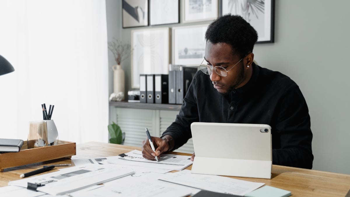 Accountant reviewing information on a graph while sitting at a desk