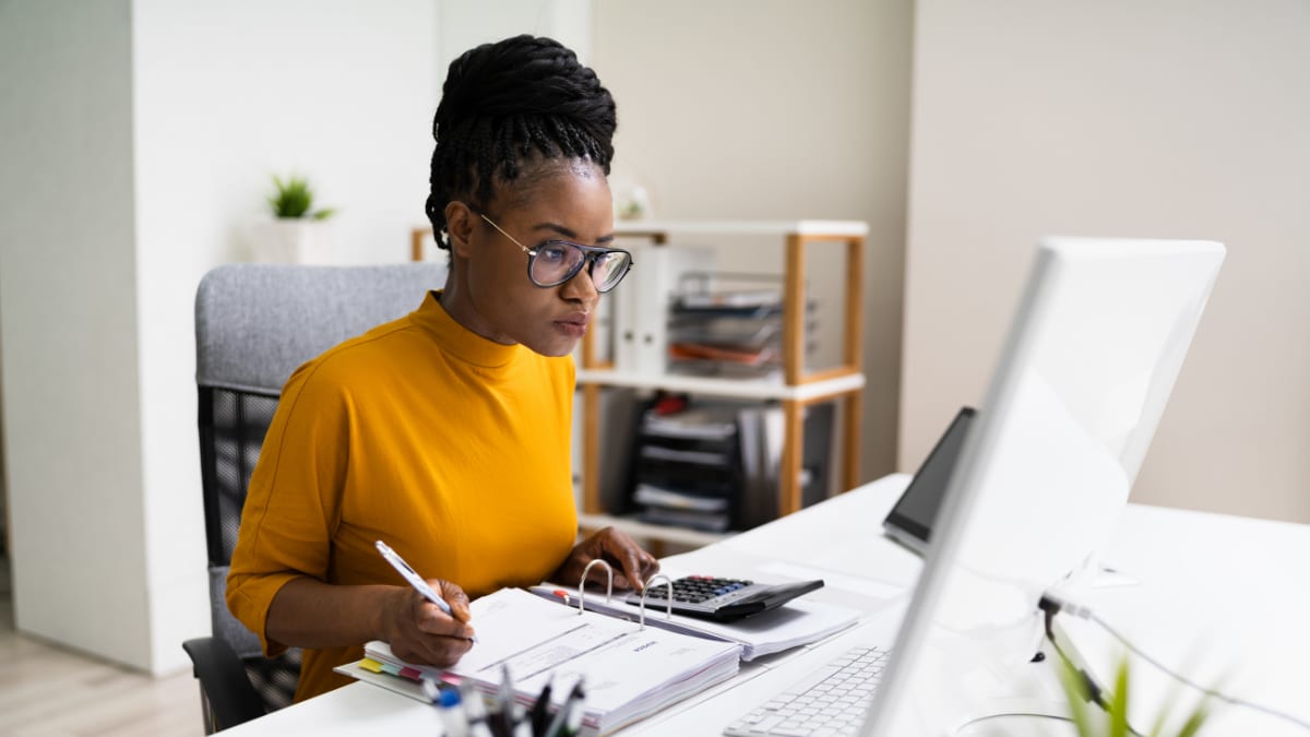 accountant sitting in front of a computer reviewing invoices