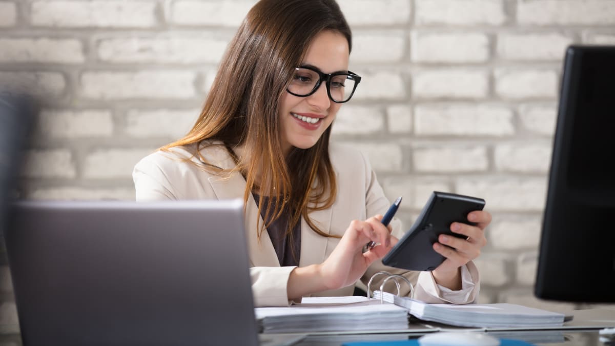 accountant with a calculator in hand looking over invoices