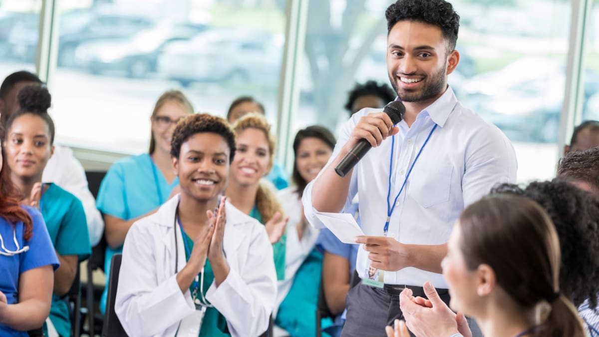 healthcare administrator answering a question during a medical conference