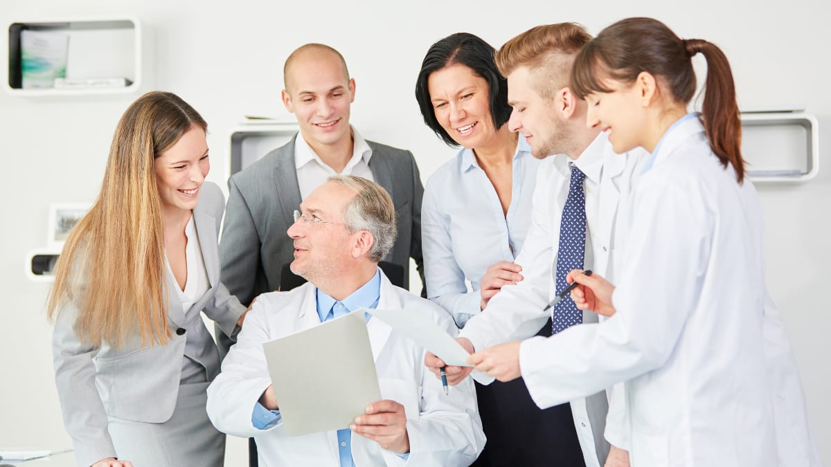 hospital staff and healthcare administrators discuss a document