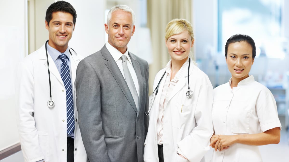 healthcare administrator standing with two doctors and a nurse