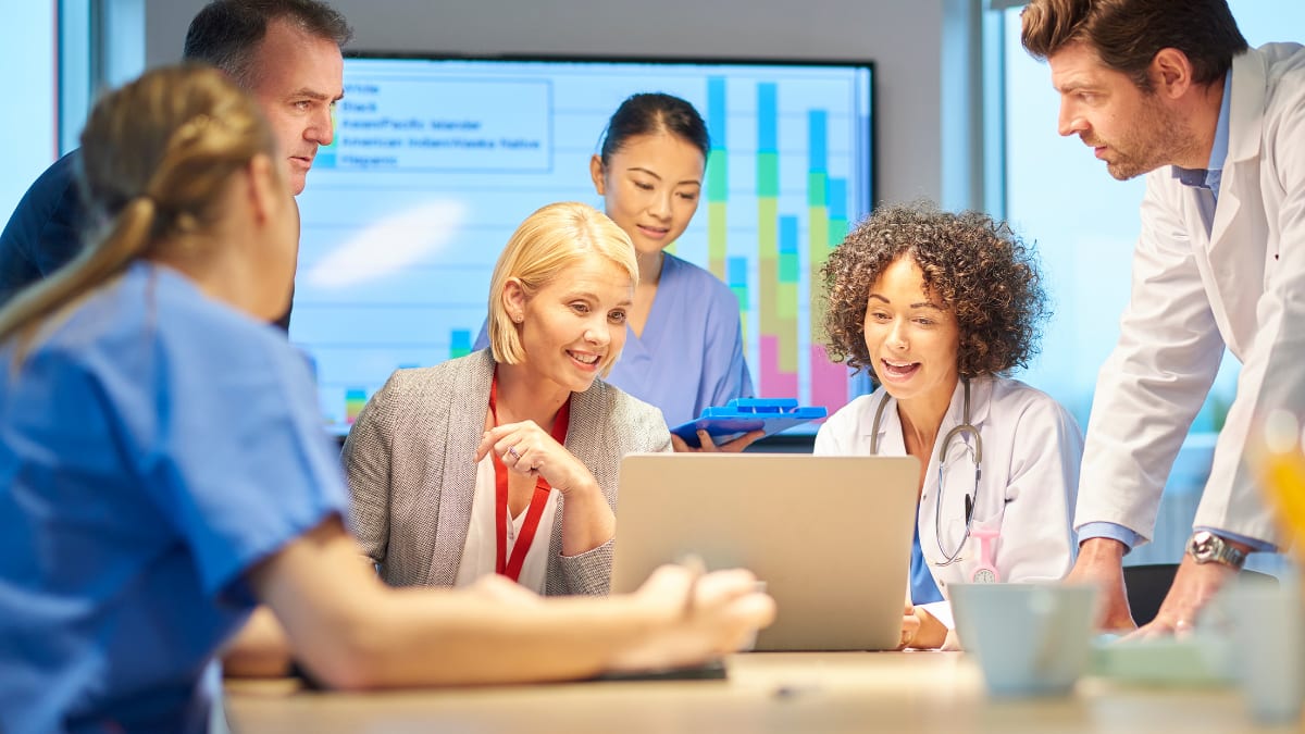 healthcare administrator giving a presentation to a group of healthcare professionals