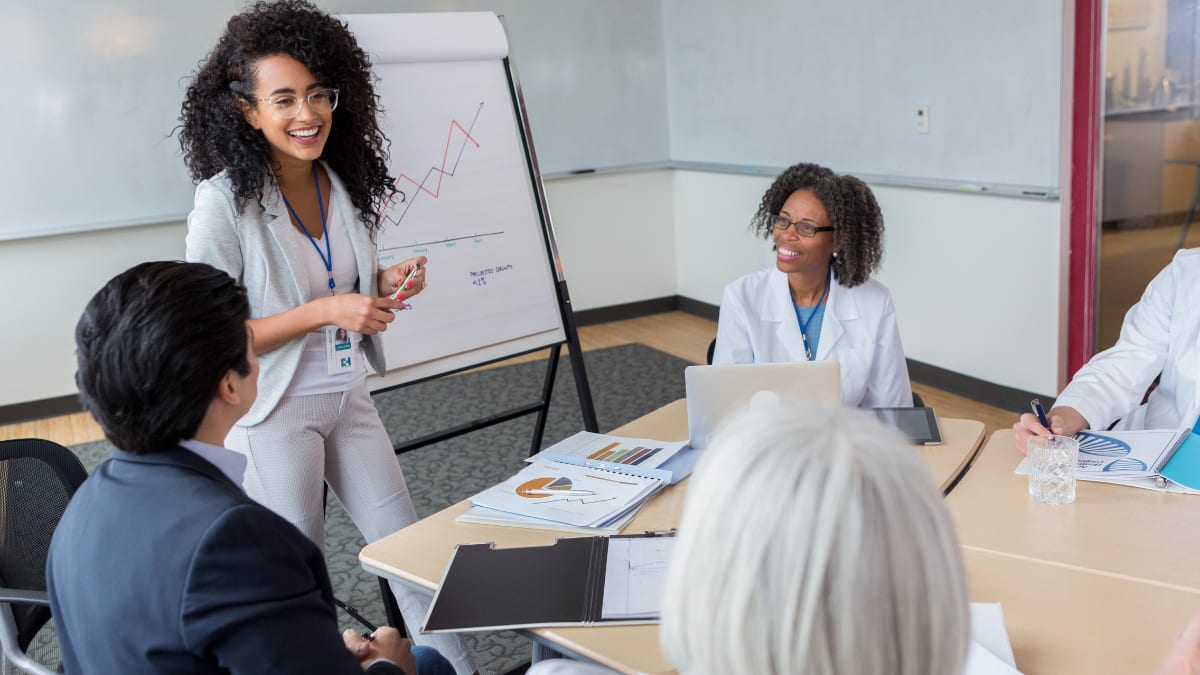 healthcare administrator talking to a group of healthcare professionals