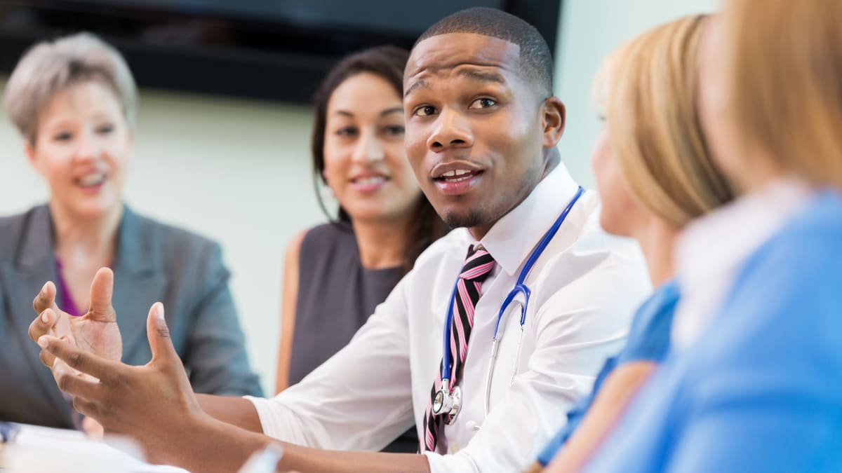 healthcare management talks with a group of healthcare professionals