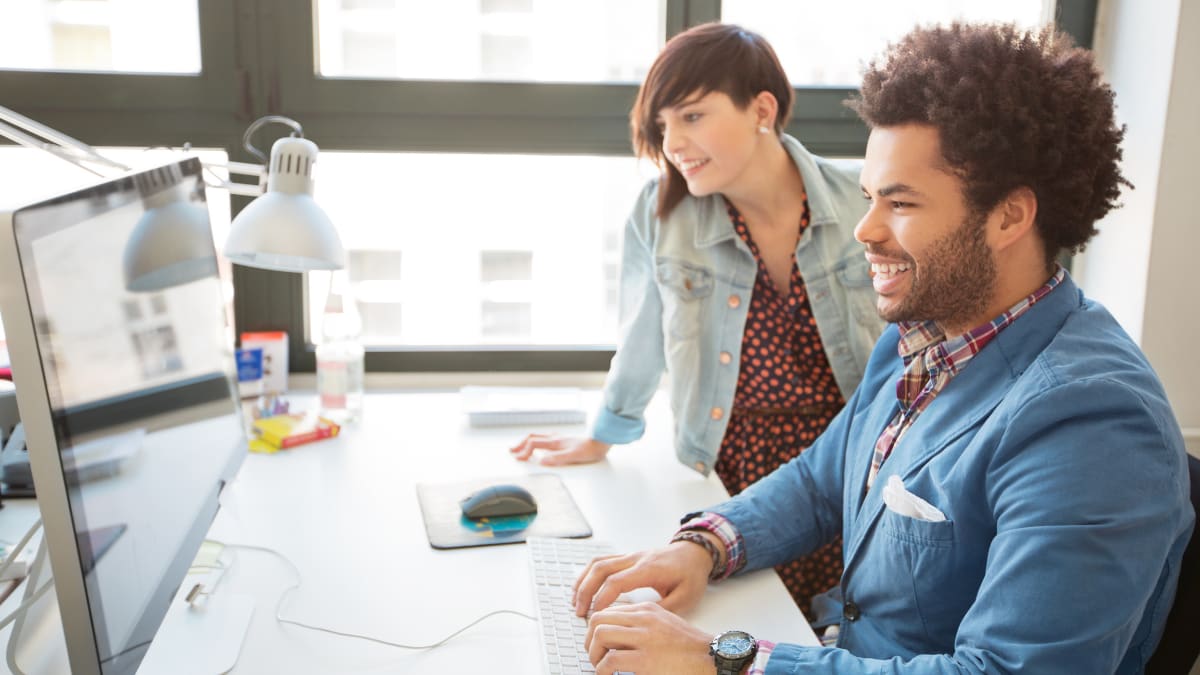 two IT professionals working together in front of a computer