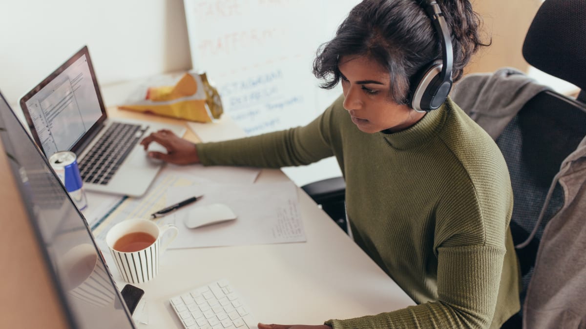 programmer sitting at her desk working in an IT office