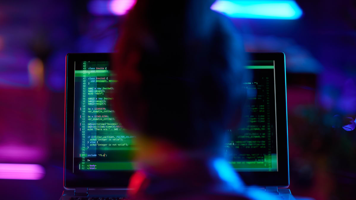 programmer sitting in front of a computer working on cybersecurity data