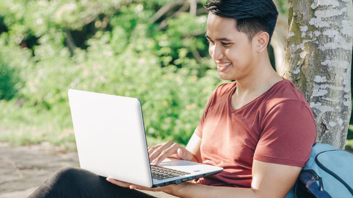 online student working on courses while outside