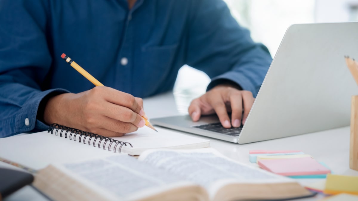 student sitting at a laptop working on online courses