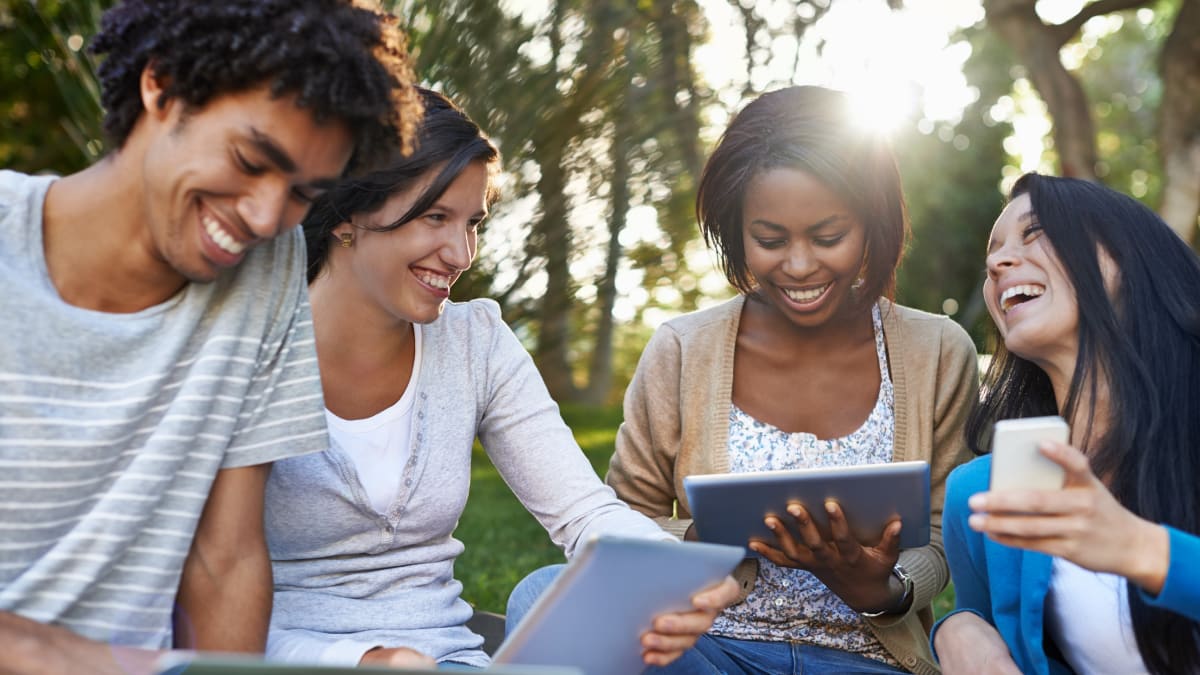 group of community college students sitting outside together