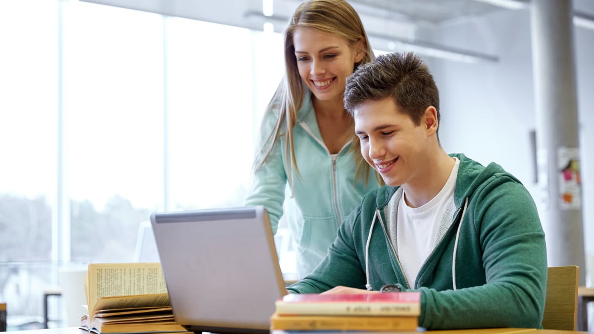 two online college students looking at a laptop